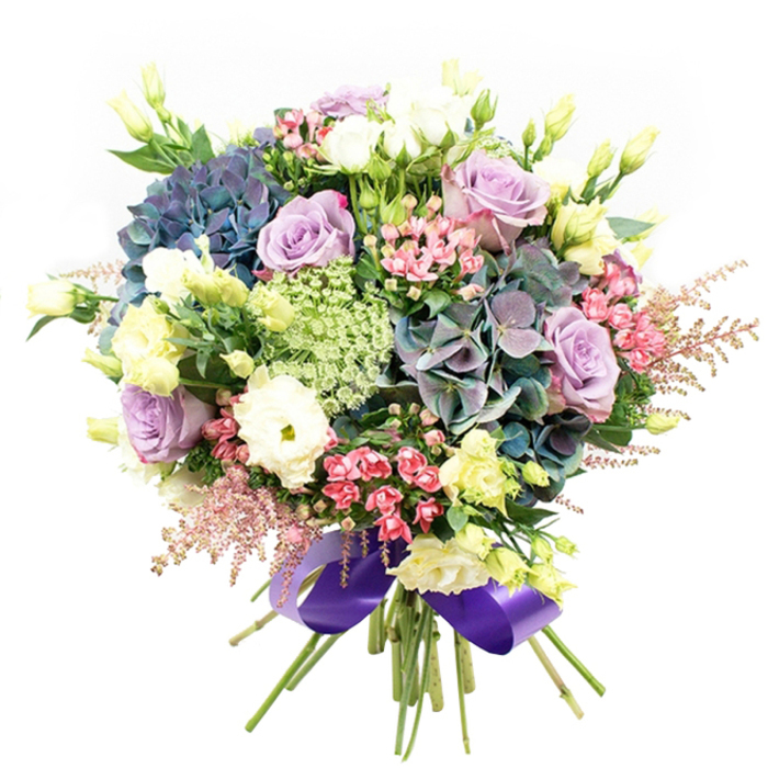 Bathed in soft daylight and set against a crisp white backdrop, this expertly arranged bouquet celebrates the floral abundance of Covent Garden. An intricate gathering of blooms centres on plush hydrangeas in velvety indigo, teal-green, and violet, their generous clusters evoking the lush displays found beneath the glass canopies by the Apple Market. Among the hydrangeas are elegant roses-some a gentle lavender, others a creamy white-each petal unfurling with poise, offering an air of graceful sophistication. At the heart of the arrangement, snowy ranunculus flowers provide a cushion of delicate ruffled layers, enhanced by the pale buttery hints of slender eustoma buds, whose subtle brightness conjures a sense of early morning light along Floral Street. Wispy fuchsia-pink flowers and ethereal blush pink astilbe trail at the bouquet's periphery, echoing the whimsical artistry woven through Covent Garden's historic passages. Fine, lacy green and white filler flowers tuck between the larger blooms, their intricate patterns reminiscent of the ornate architecture found nearby. Strategic sprigs of verdant foliage add contrast and freshness, snugly encasing the bouquet in natural beauty. The arrangement's stems are gathered and finished with a sumptuous royal purple satin ribbon, its glossy sheen harmonising perfectly with the cool, romantic palette. Perfect for celebrating love, marking milestones, or adding a sophisticated touch to gatherings near the West End, this bouquet captures both the creativity and timeless elegance that define Covent Garden floristry.